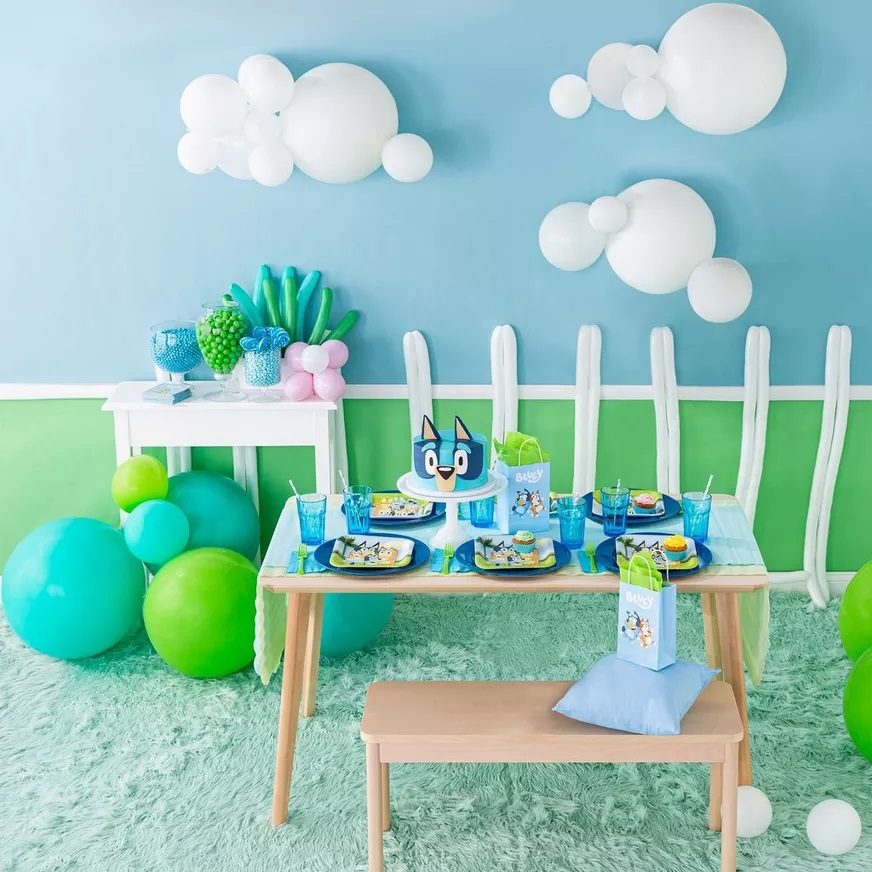 Bluey birthday party supplies including balloons, plates and decorations in blue and orange
