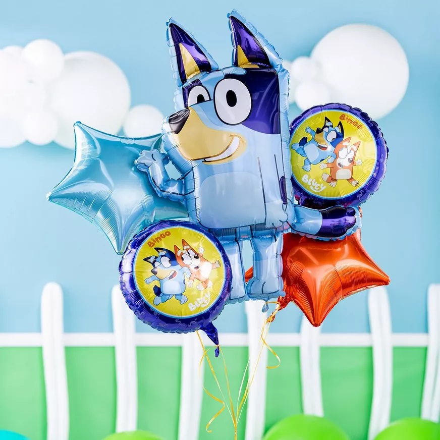 Bluey party decorations including themed banner, blue and orange balloons and party tableware